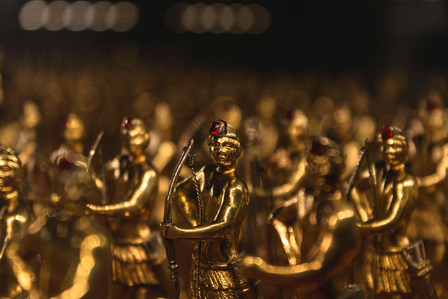 male holding bow gold-colored figurine lot, statue, figure HD wallpaper