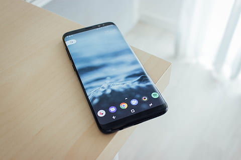 selective focus photography of turned on midnight black Samsung Galaxy S8 displaying home screen, black Android smartphone on beige top table HD wallpaper