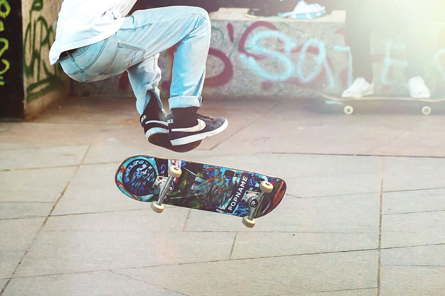 man playing blue and black skateboard during daytime, skateboarder