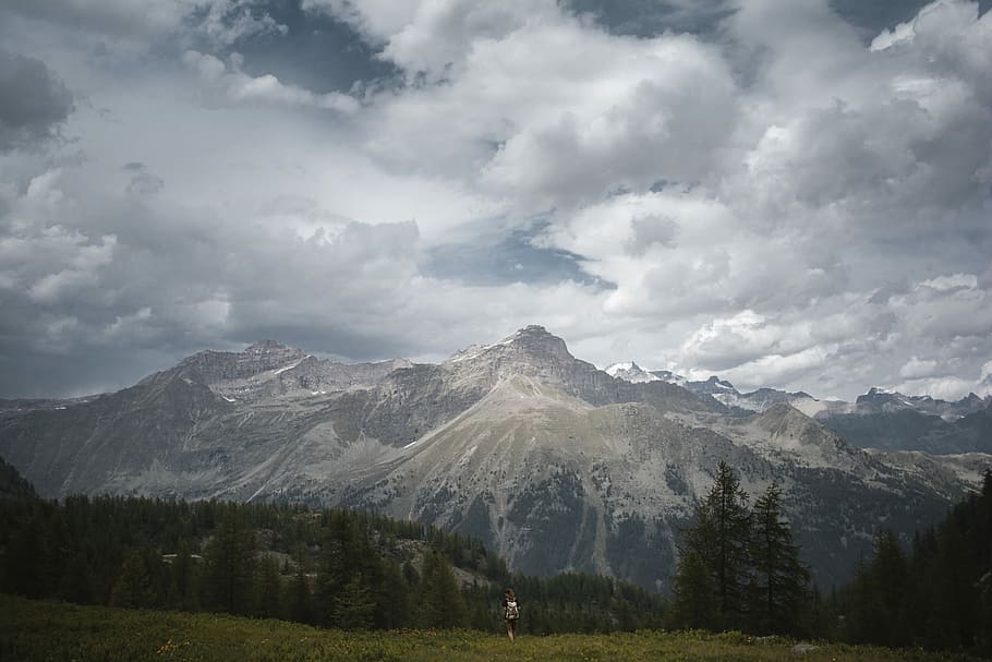 mountain under white clouds, gray mountains near trees during gray sky HD wallpaper