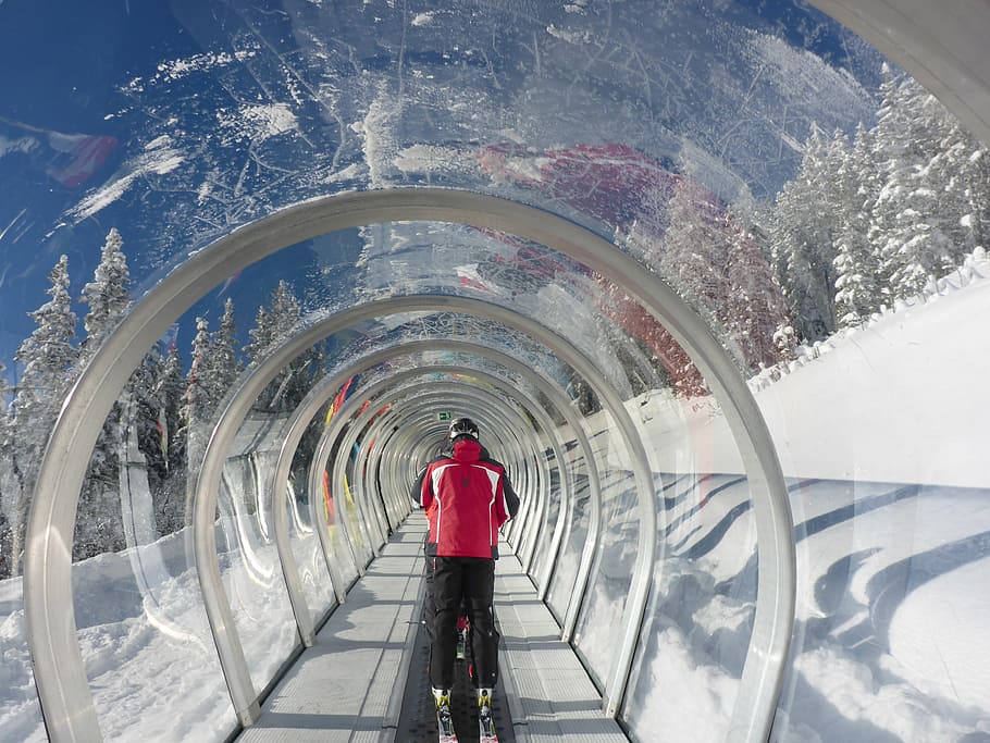 man in red jacket inside tunnel, lift, treadmill, skiing, transport