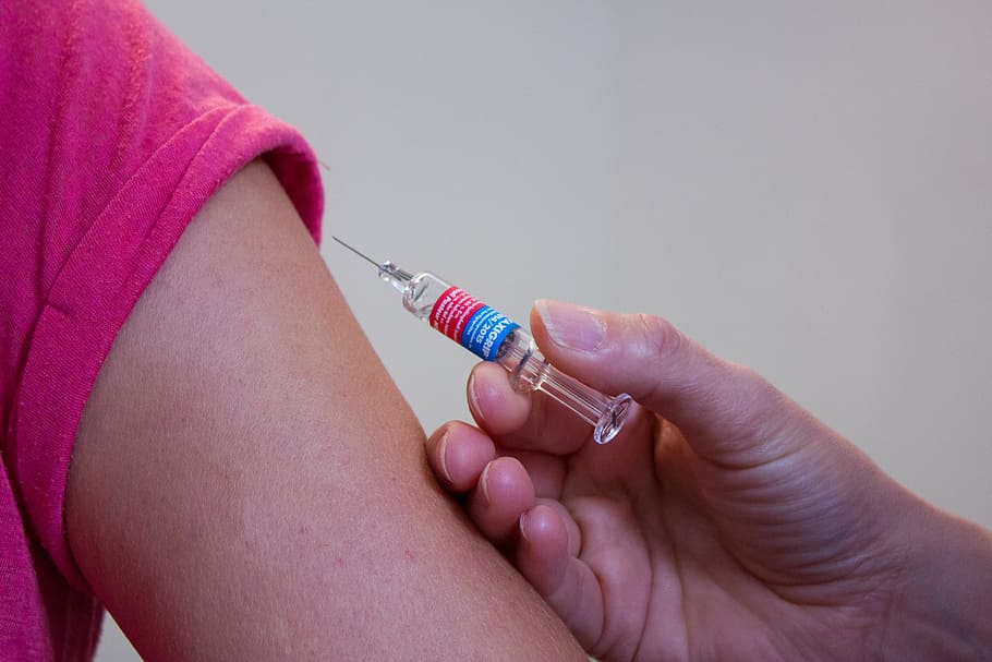 person holding syringe on person's arm, vaccination, doctor, medical