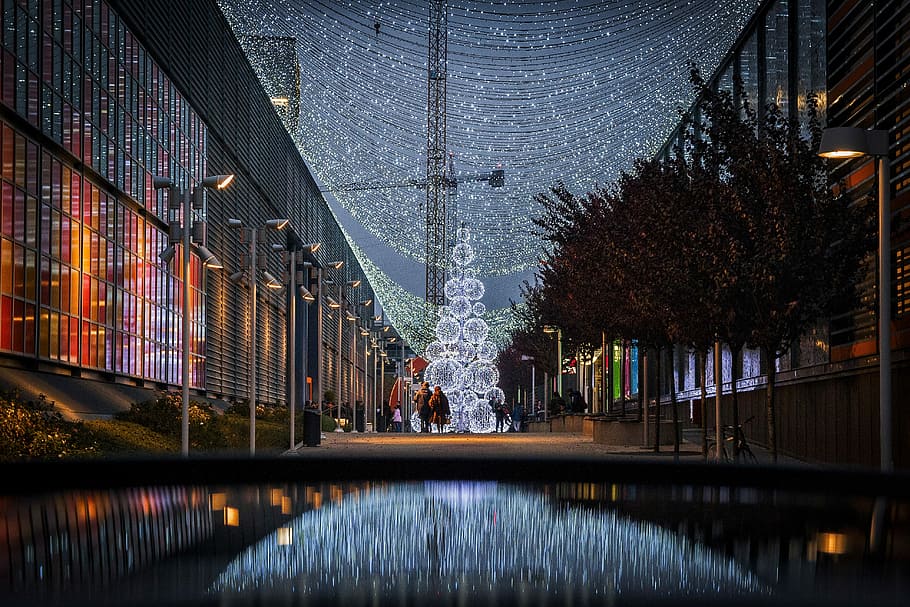 photography of lights, two person walking near building and trees during nighttime HD wallpaper