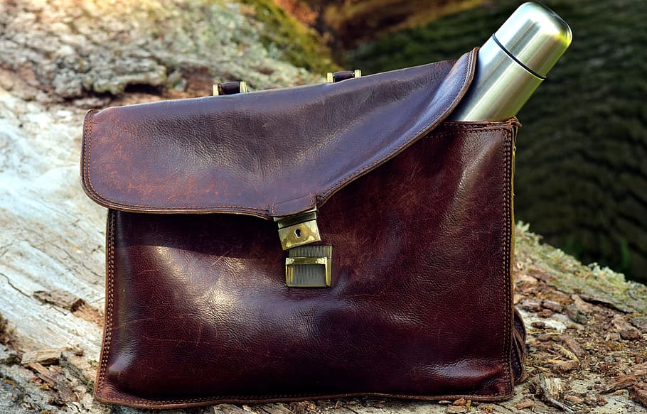 gray stainless steel vacuum flask on brown leather bag on brown wood trunk at daytime HD wallpaper