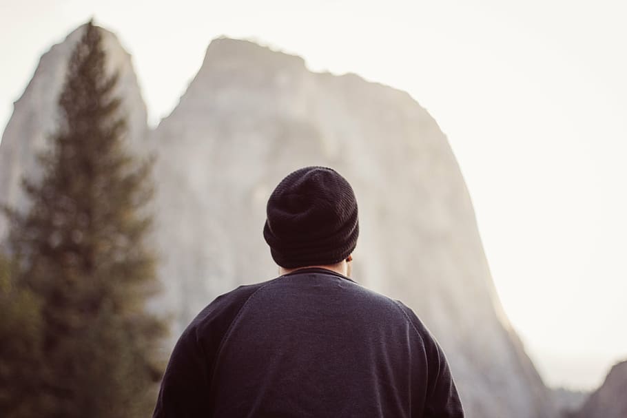 person wearing black cap facing rock formation, man, gazing HD wallpaper