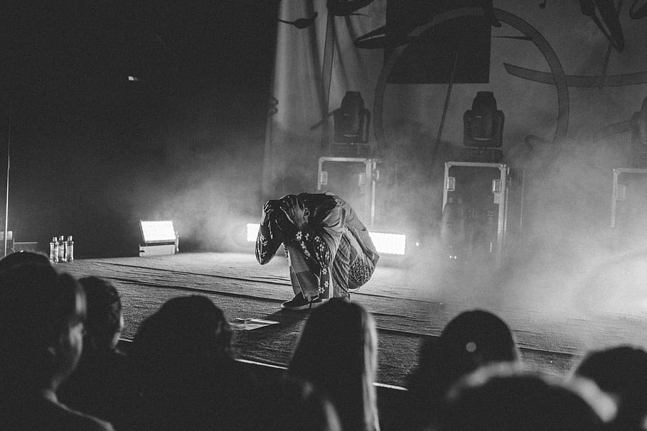 people performing on stage, man sitting while both hands holding his head HD wallpaper
