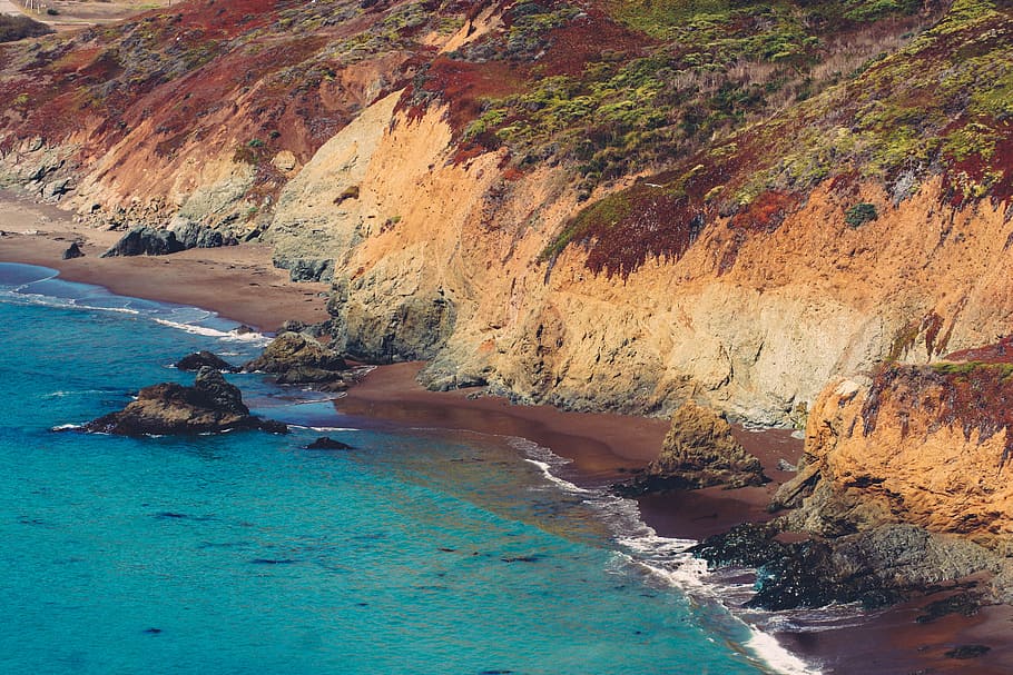 birds eye view of shore and mountain, body of water near brown mountain HD wallpaper