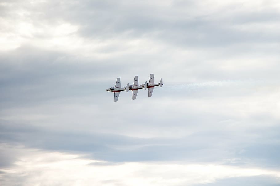 three flying white planes under cloudy sky during daytime, snowbirds