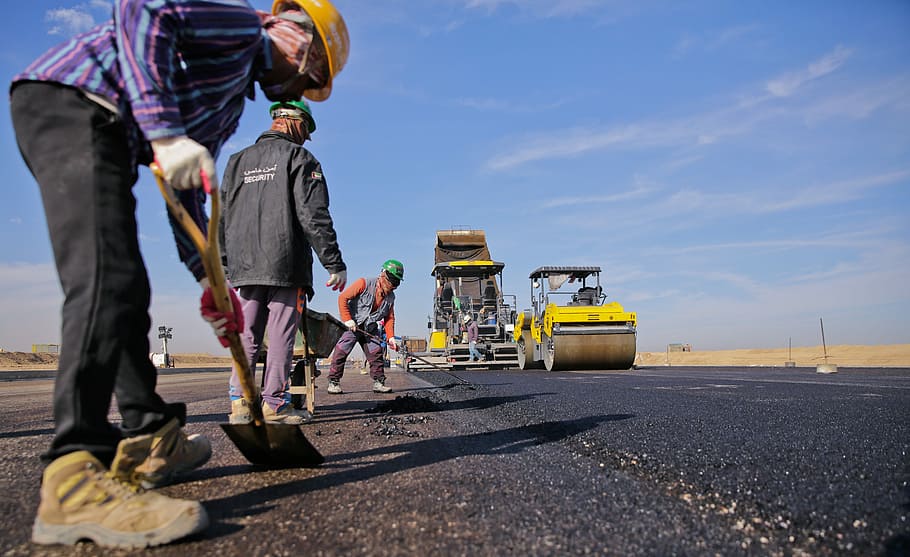 four men working on concrete roadway holding shovel at daytime HD wallpaper