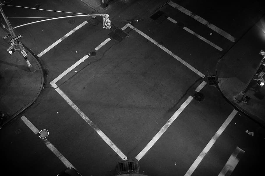 A look down at an empty intersection where traffic lines form a square, aerial photography of street crossing HD wallpaper