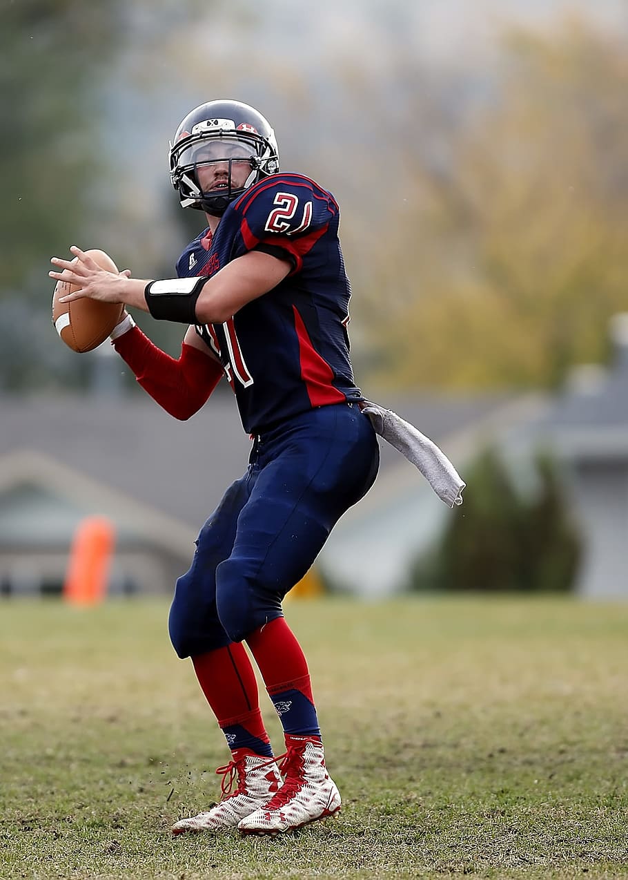 selective focus photography of football player holding football