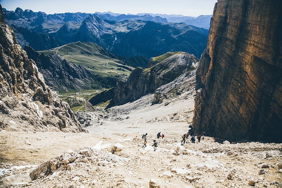 landscape photo of group of person walking on mountain, group of people walking near brown rocky mountain during daytime photo HD wallpaper