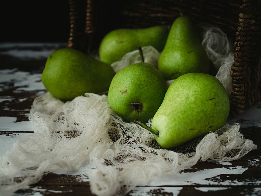 bunch of green pear fruit, close-up photography of five green fruits beside brown wicker basket, HD wallpaper