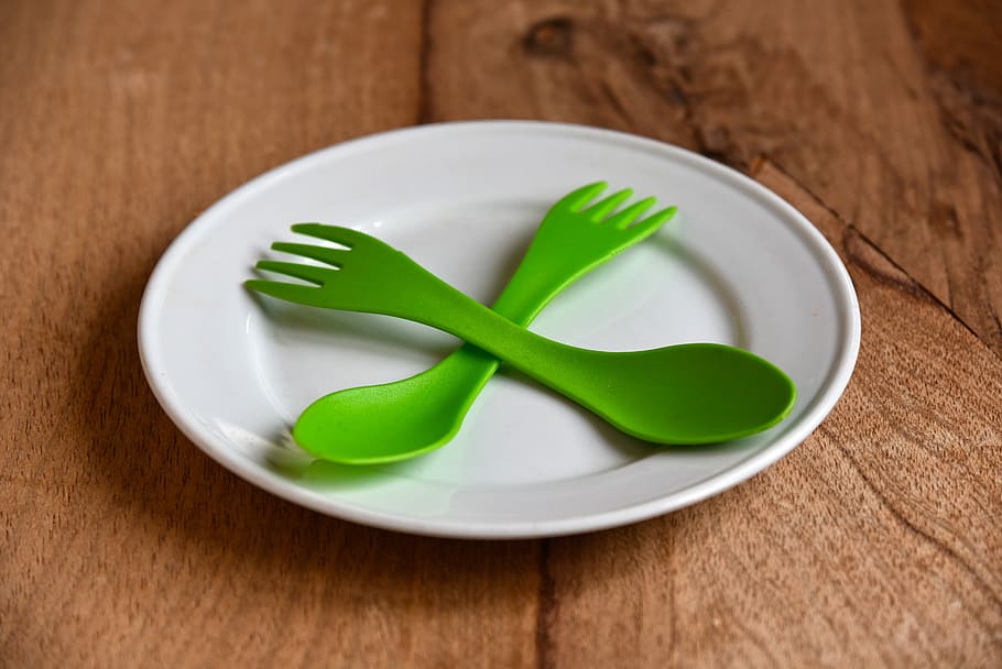 green plastic spoon and fork on top white plate, china, eating