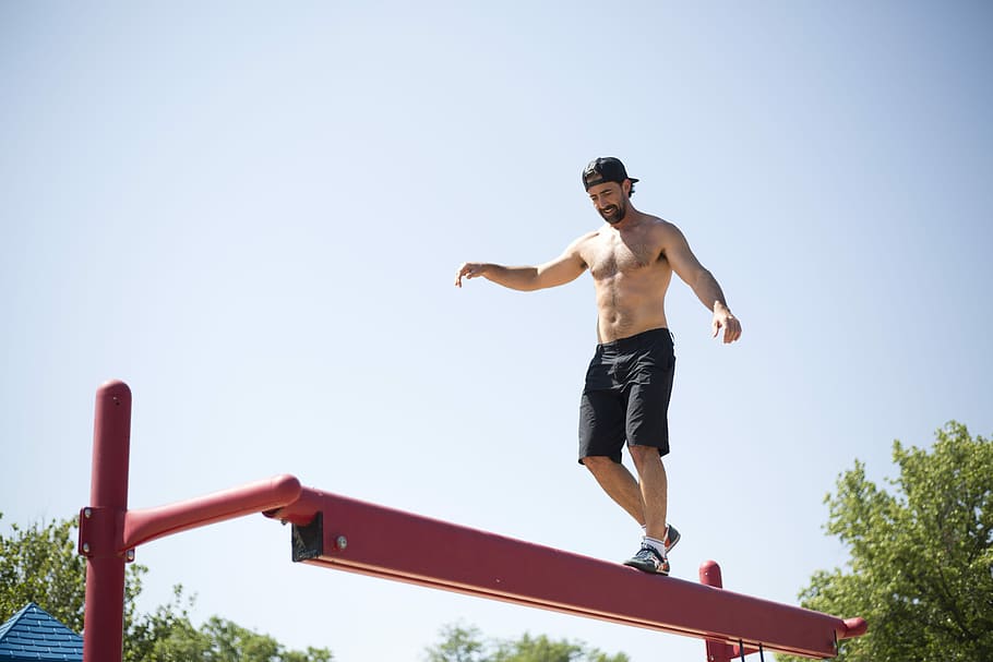 Balance at the Playground, man walking through red steel platform, HD wallpaper