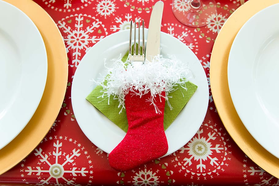 red Christmas stocking with fork and knife on white ceramic plate HD wallpaper