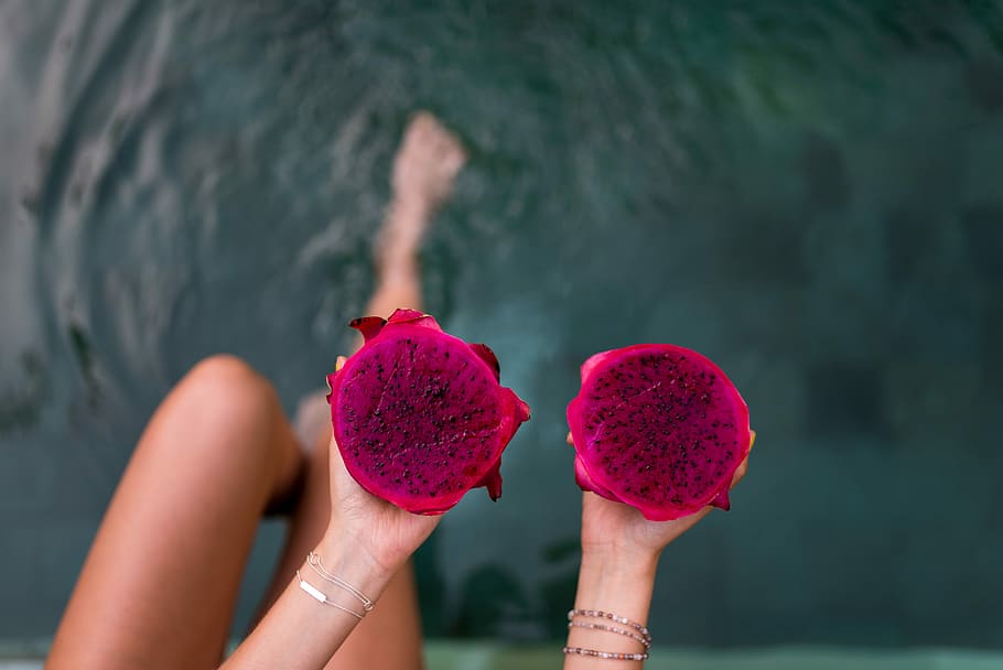 person holding two pink fruits, person holding dragon fruits HD wallpaper