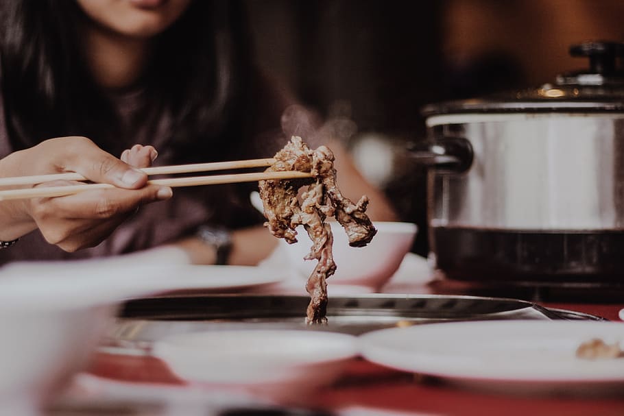woman holding beige chopsticks, person holding chopsticks while picking up a cooked meat HD wallpaper