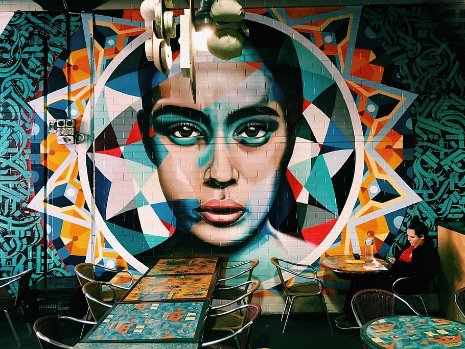 woman sitting near graffiti, woman sitting alone in front of round table