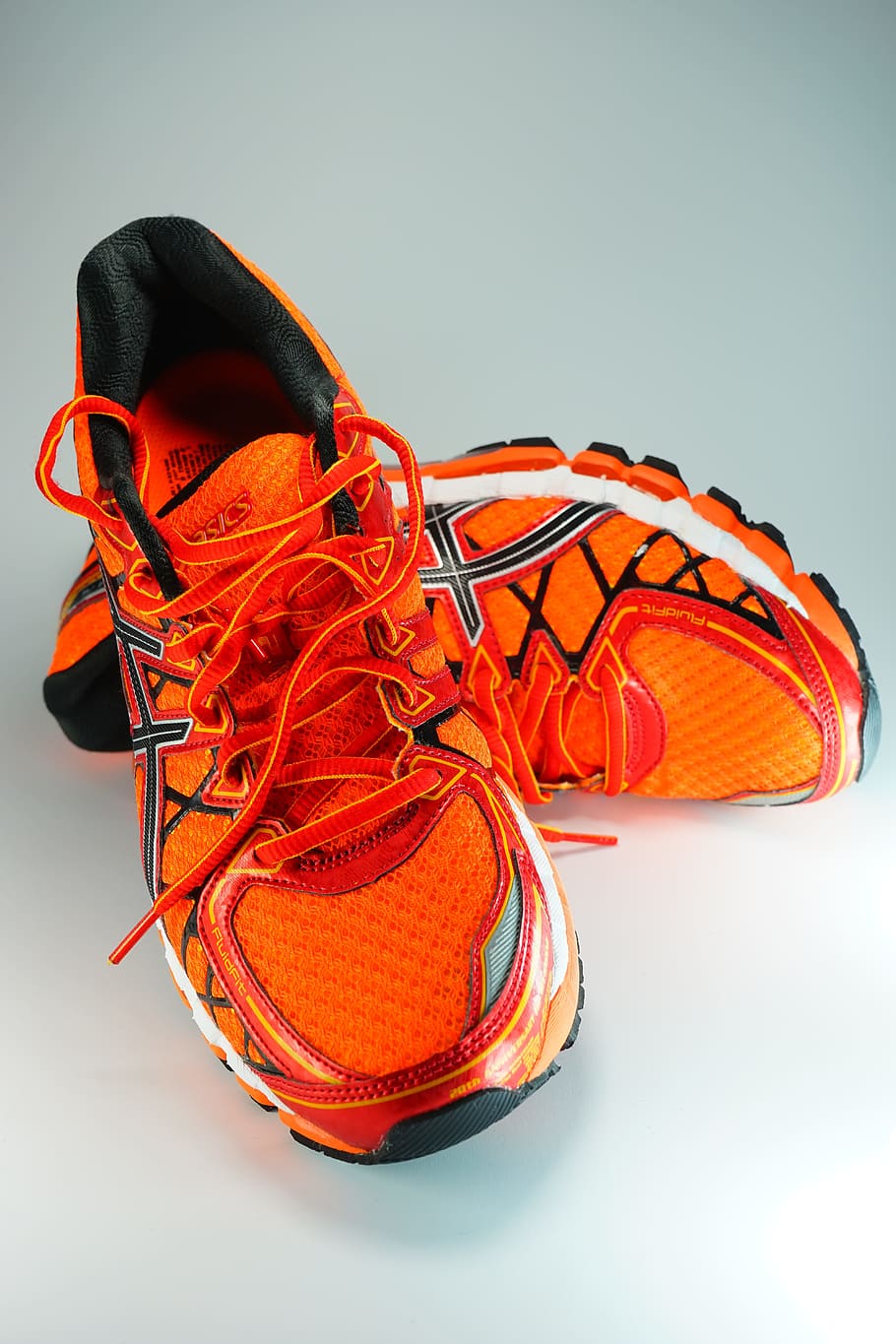 pair of orange-and-white ASICS running shoes, sneakers, sports shoes
