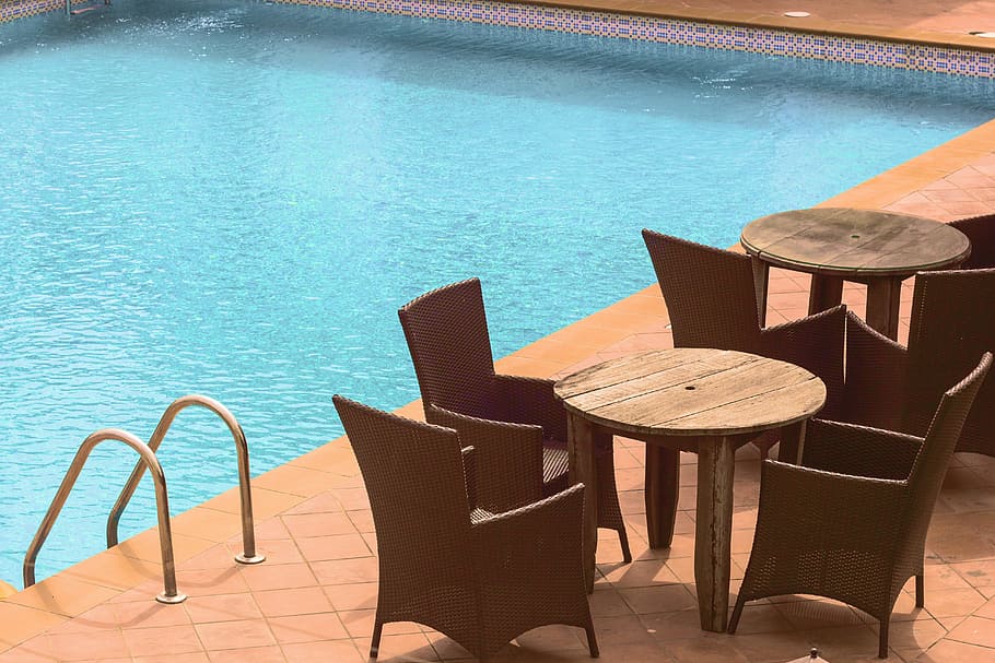 wooden cafe table and chairs beside inground pool, closeup photo of table and chairs near pool HD wallpaper