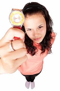woman in pink top holding round silver-colored analog watch with red strap HD wallpaper