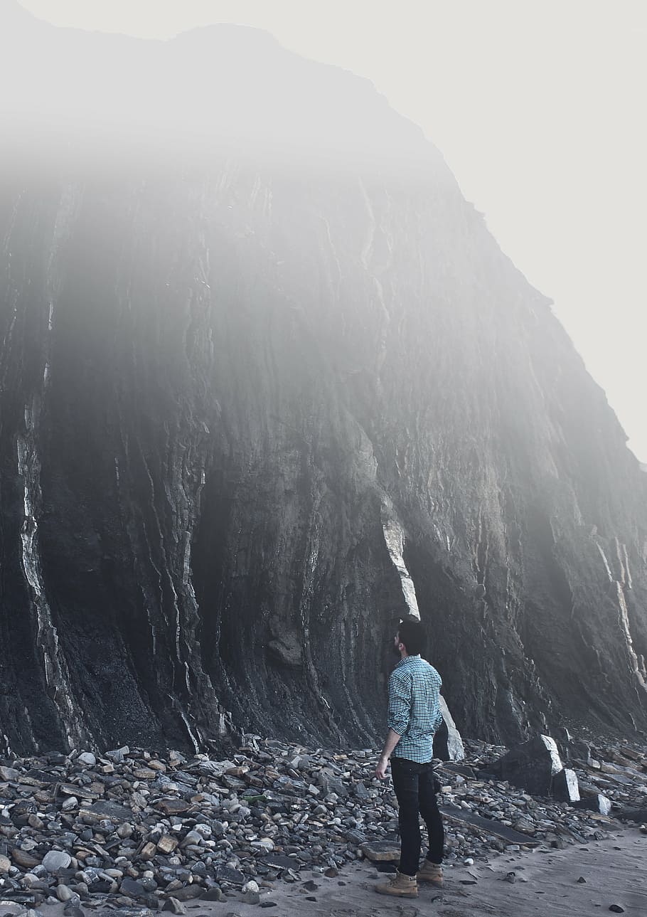 man looking up black rock mountain, people, guy, alone, hill, HD wallpaper