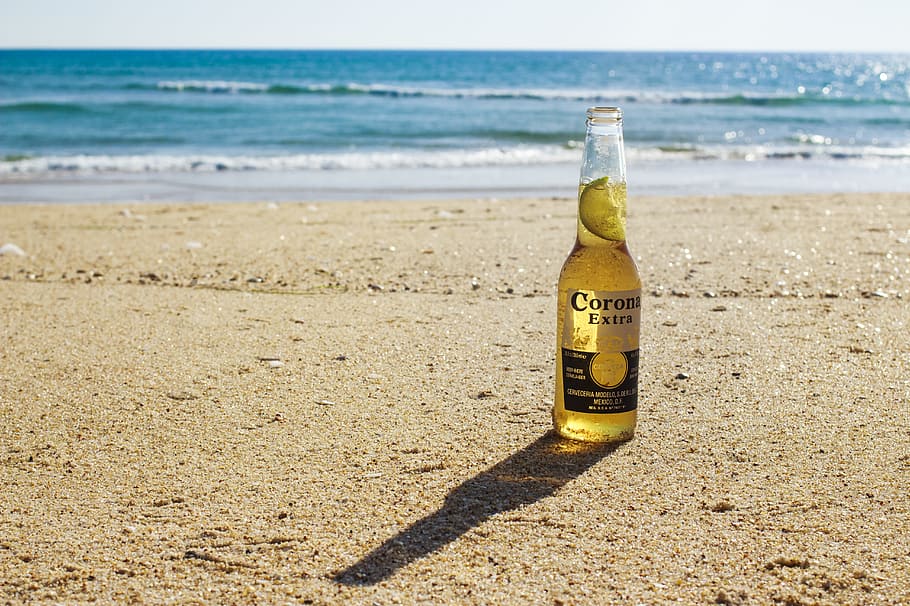 Corona Extra bottle on seashore during daytime, shallow focus photography of Corona Extra bottle, HD wallpaper