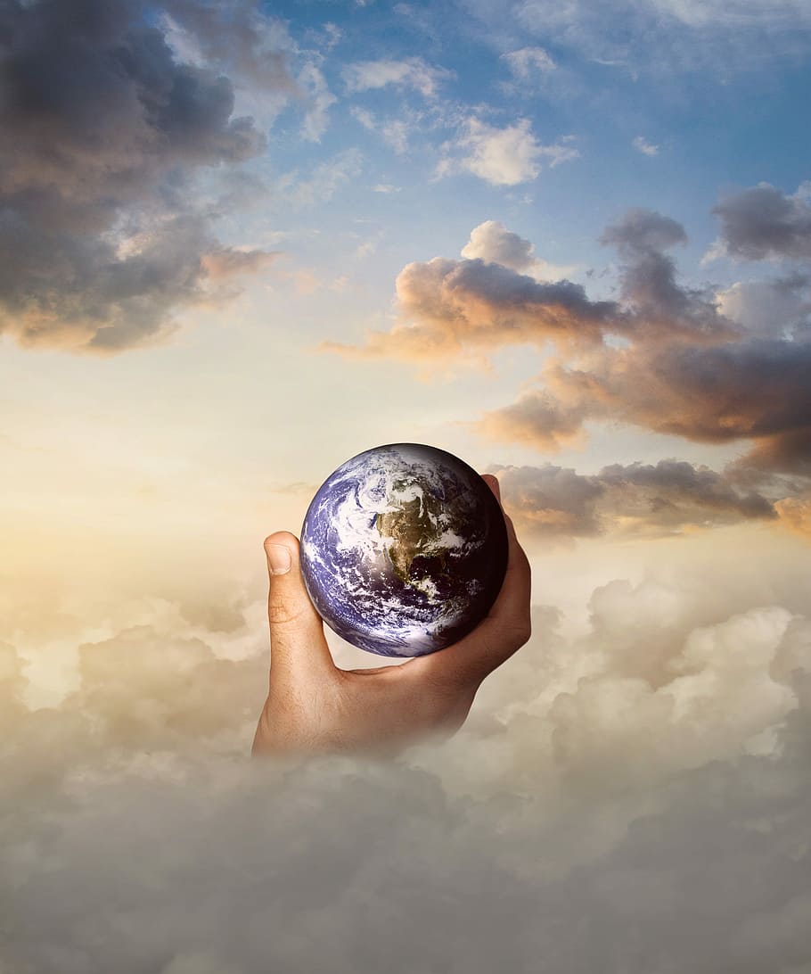 person holding earth digital wallpaper, globe, hand, clouds, sky