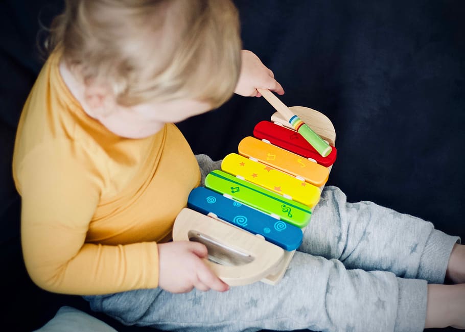 toddler playing wooden xylophone toy, boy playing xylophone, child