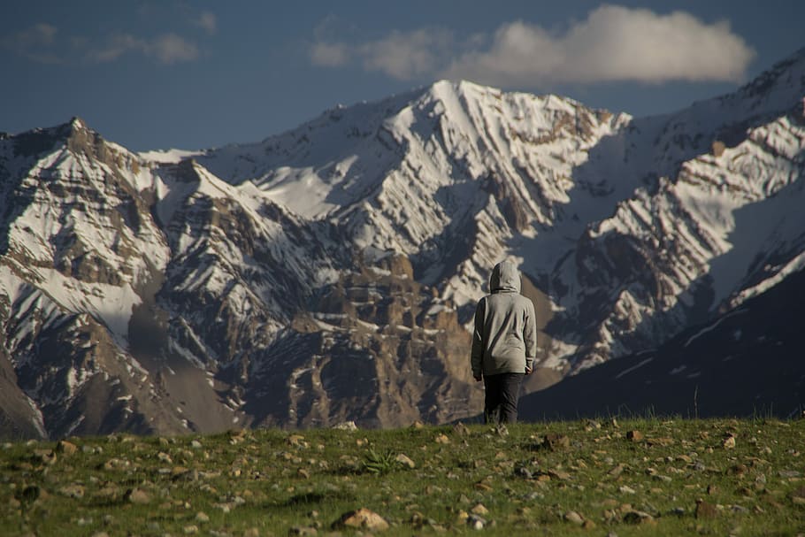 man standing looking at tundra mountain, man standing on grass field HD wallpaper