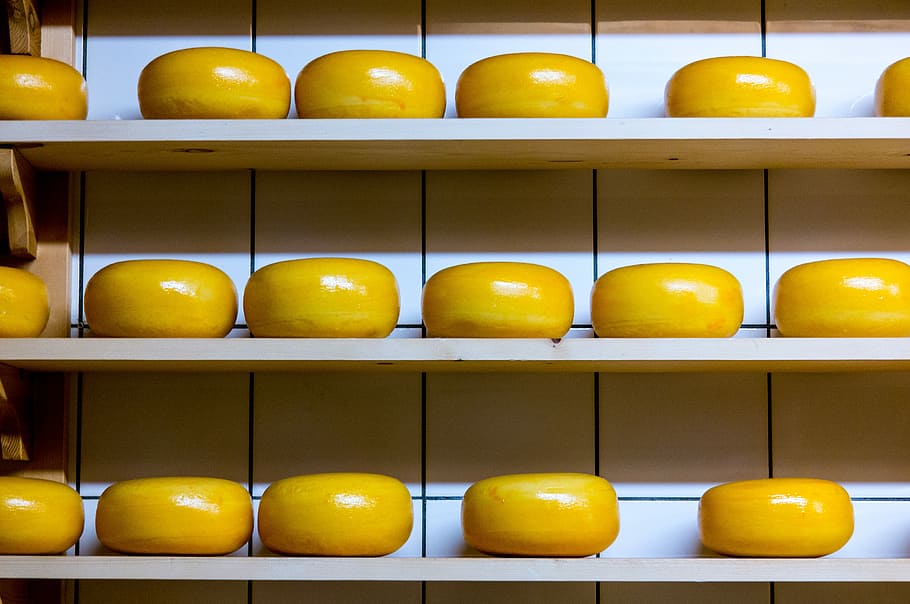 yellow cheese lot on brown wooden shelf, oval yellow fruit lot on shelves HD wallpaper