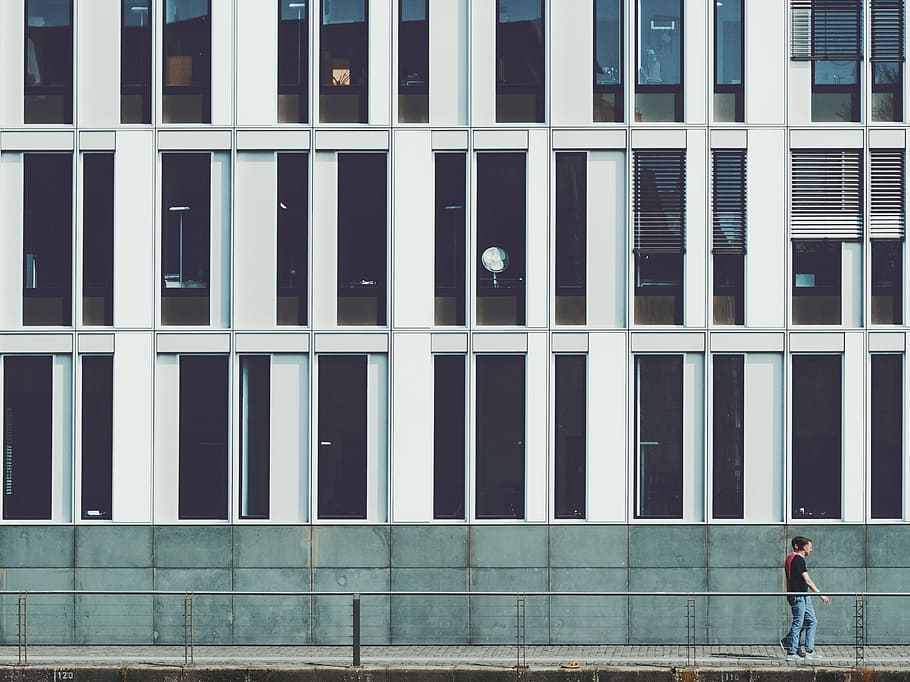 two men walking beside building, people walking on sidewalk near building HD wallpaper