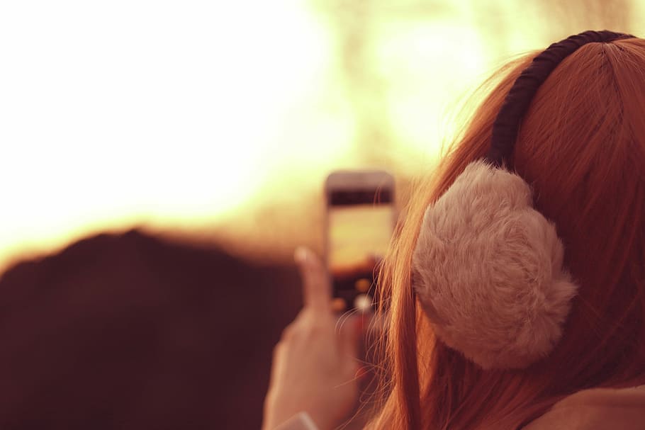 selective focus photography of woman wearing earmuffs taking camera HD wallpaper