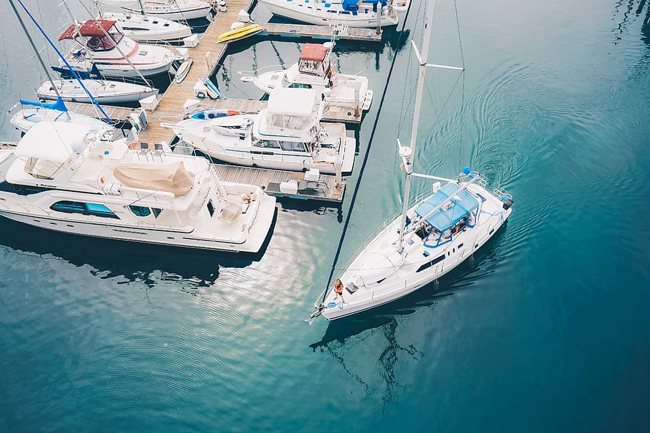 boat on body of water near dock, boat sailing near parked boat during daytime HD wallpaper
