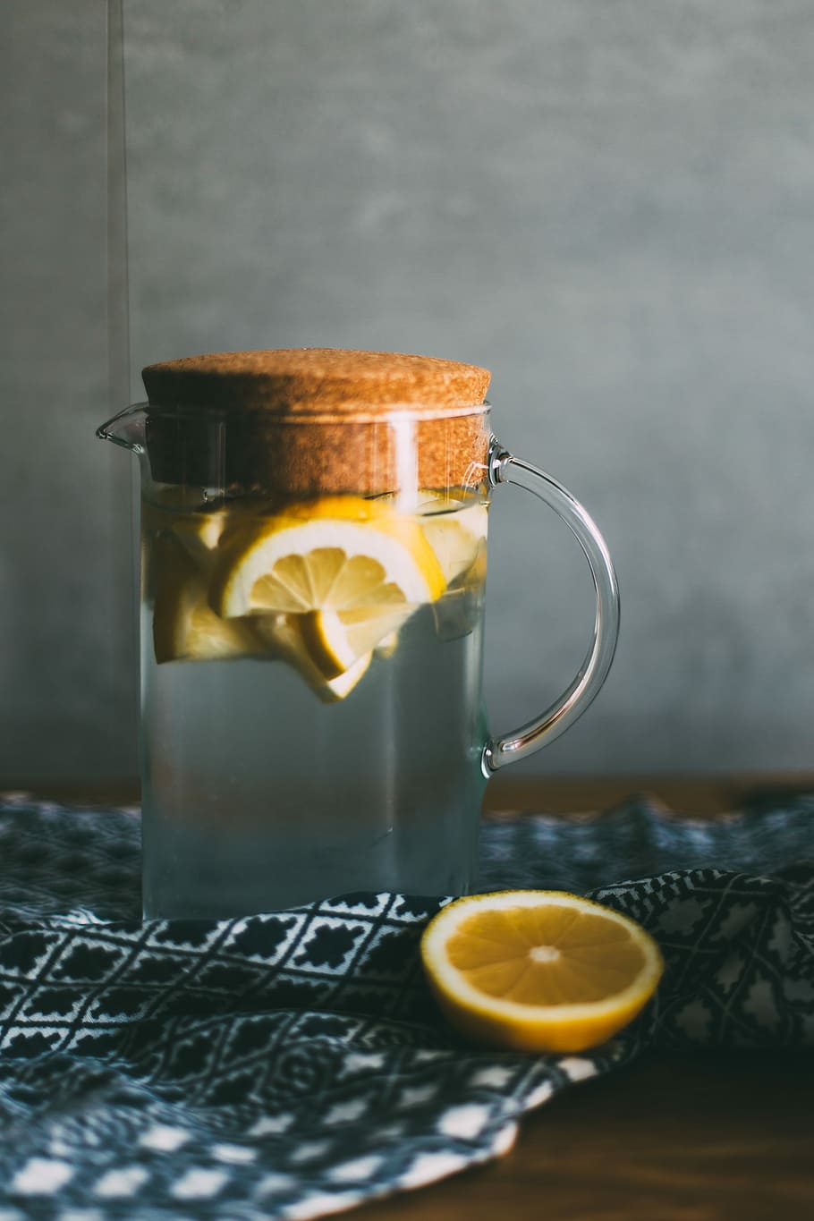 clear glass pitcher filled with sliced lemons on black and white table runner, clear glass pitcher with lemons on top of black and white textile HD wallpaper