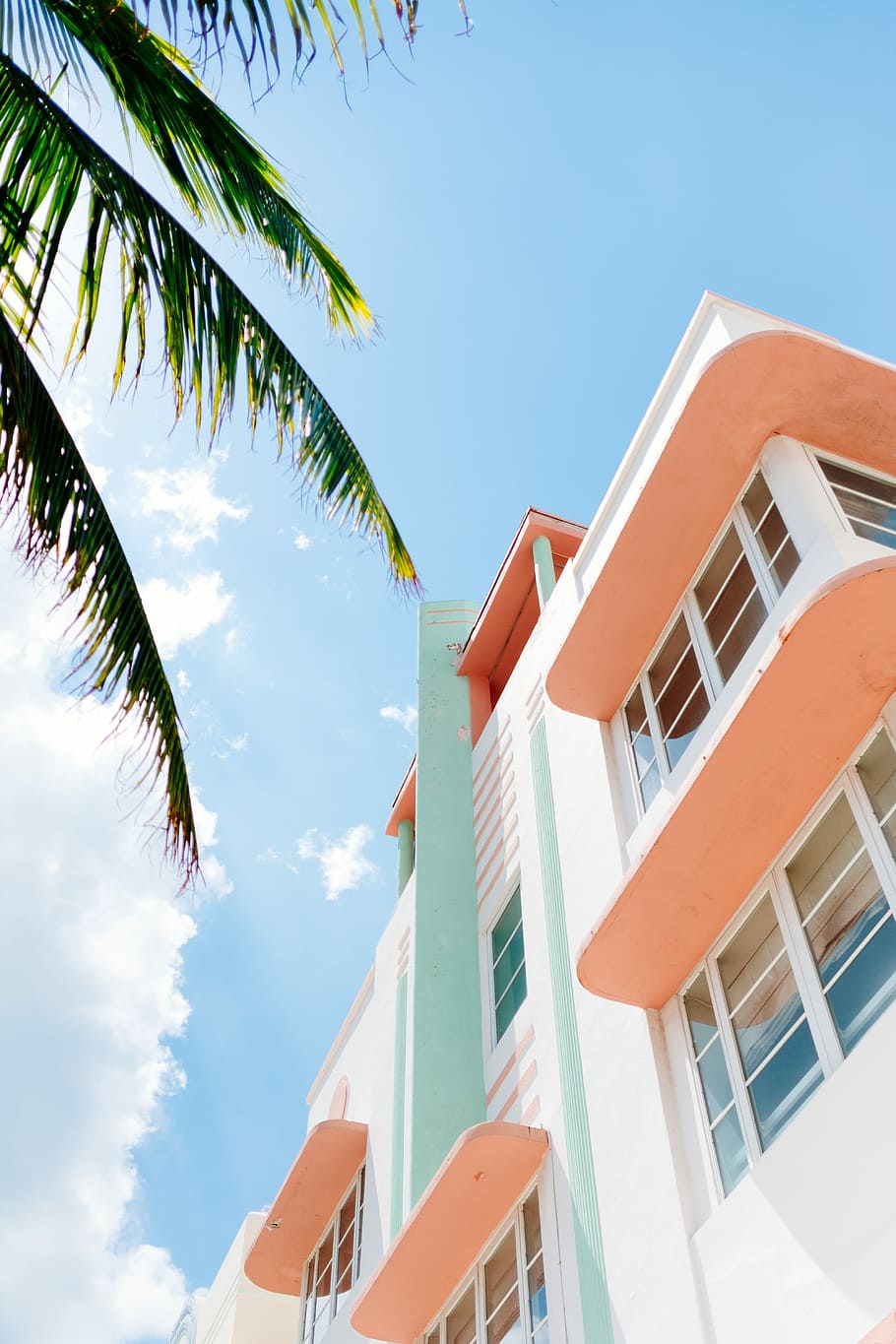 low angle photo of white and orange concrete building, pink and white concrete high-rise building HD wallpaper