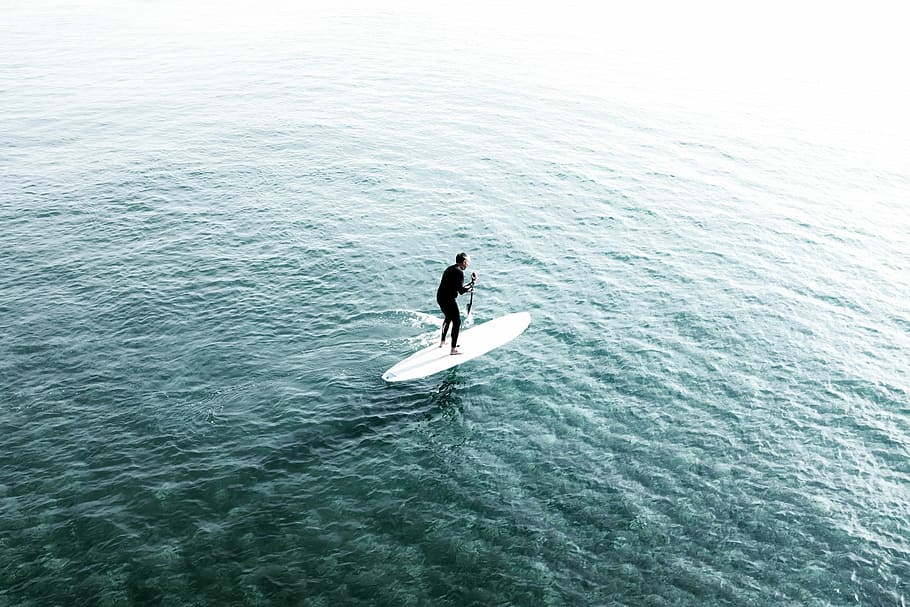 man riding surfboard on body of water, man riding on his white surfboard HD wallpaper