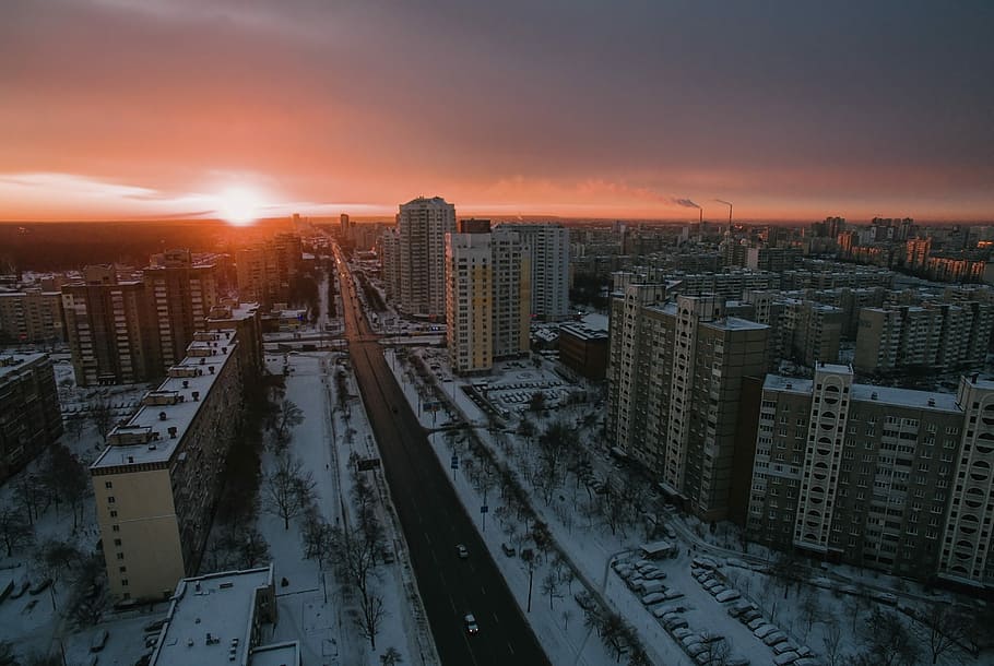 areal view of white city during sun set, aerial shot of high-rise buildings under golden sky