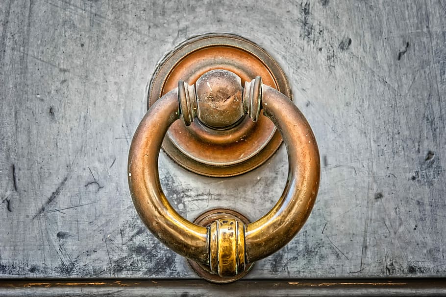 close-up photo of brass-colored door knocker, thumper, copper