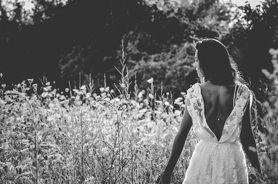 grayscale photography of woman in backless wedding gown, grayscale photography of woman in dress near plants
