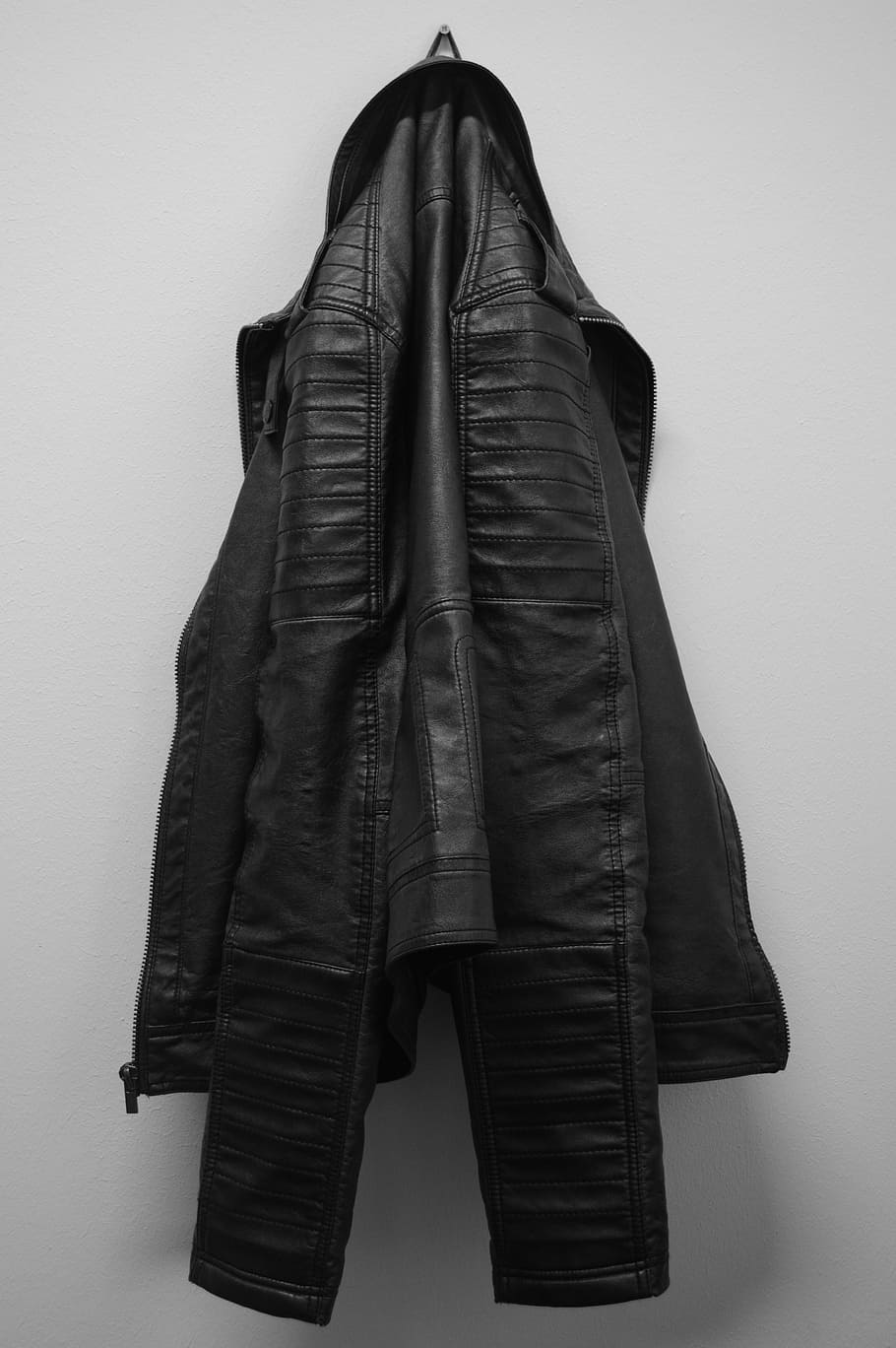 black leather jacket hanging on white wall, leather coat, clothing