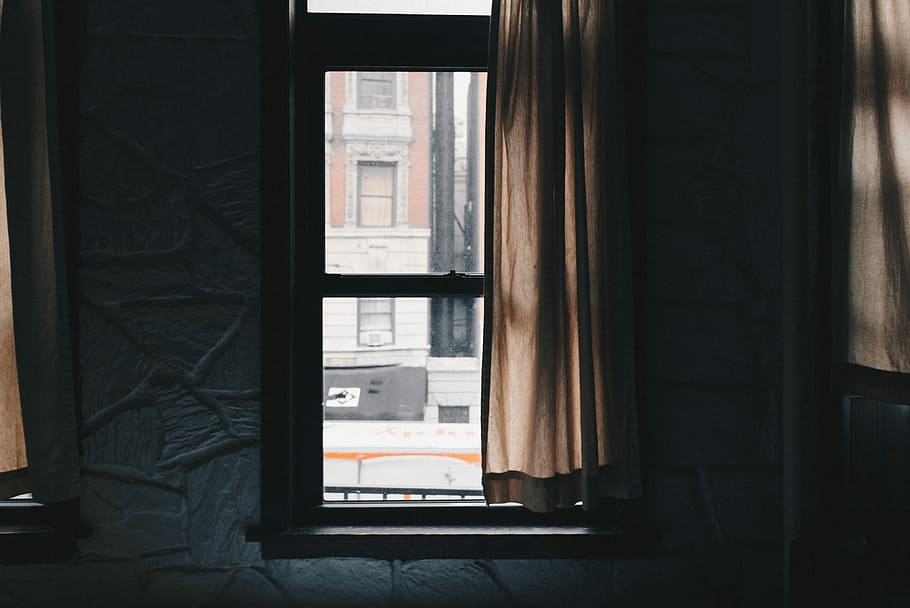 brown window curtain beside black wooden sash window, clear glass window showing brown house during daytime
