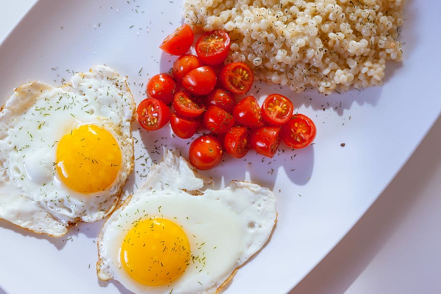 two sunny side eggs with sliced tomatoes on ceramic plate, two sunny side-up eggs with sliced cherry tomatoes HD wallpaper