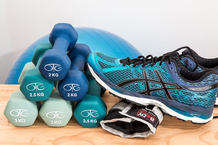 six 2 kg fixed weight dumbbells and Asics running shoe on brown table