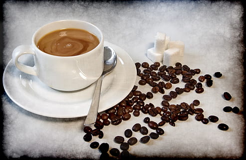 white ceramic teacup with coffee in it beside coffee beans HD wallpaper