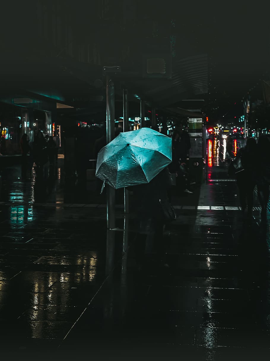 selective color photography of blue umbrella during nighttime, person holding umbrella during nighttime