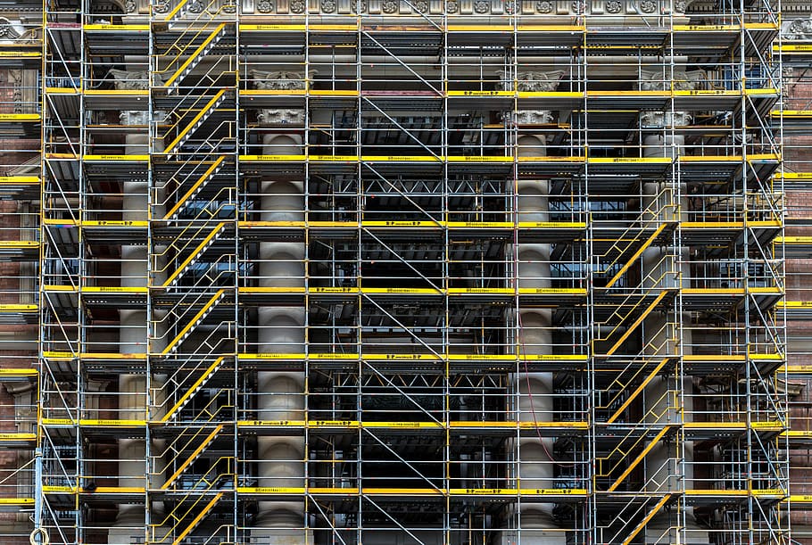 grey and brown concrete building, photo of yellow and gray scaffolding