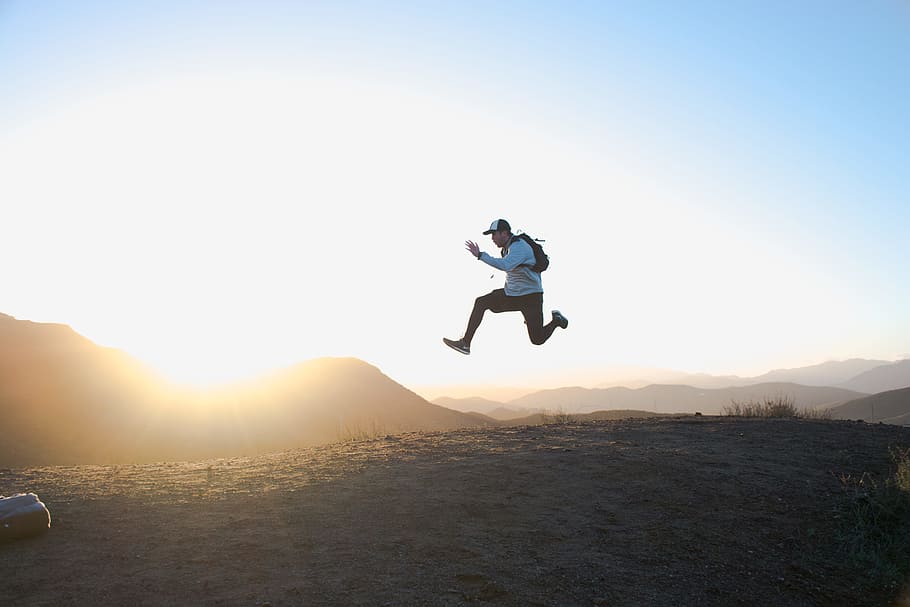 man wearing white long-sleeved shirt on air photo, man jumping