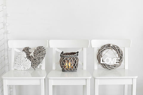 gray wicker wreath and candle holder on top of three white wooden chairs HD wallpaper